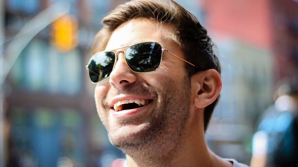 Lachender Mann mit Sonnenbrille.