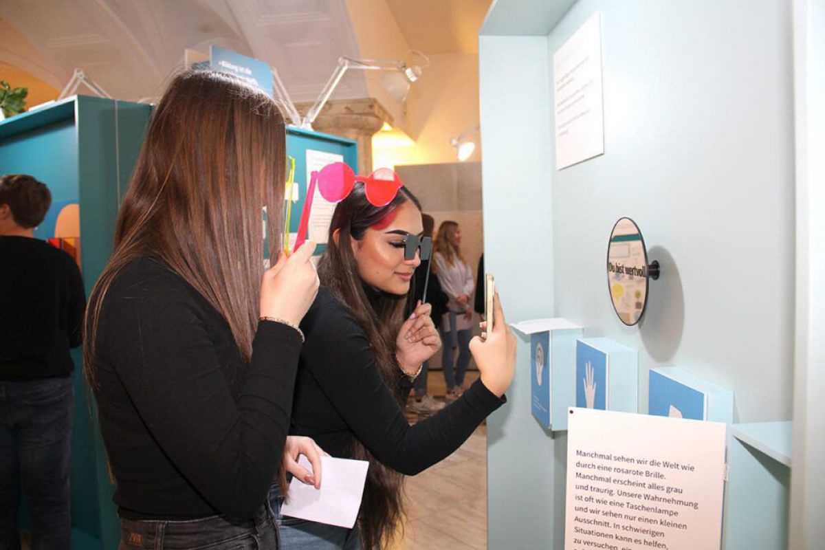 Zwei Schülerinnen stehen vor einer interaktiven Tafel bei der Ausstellung 