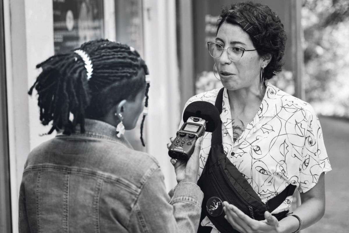 Das Schwarz-Weiß-Foto zeigt zwei Frauen bei einem Interview. 