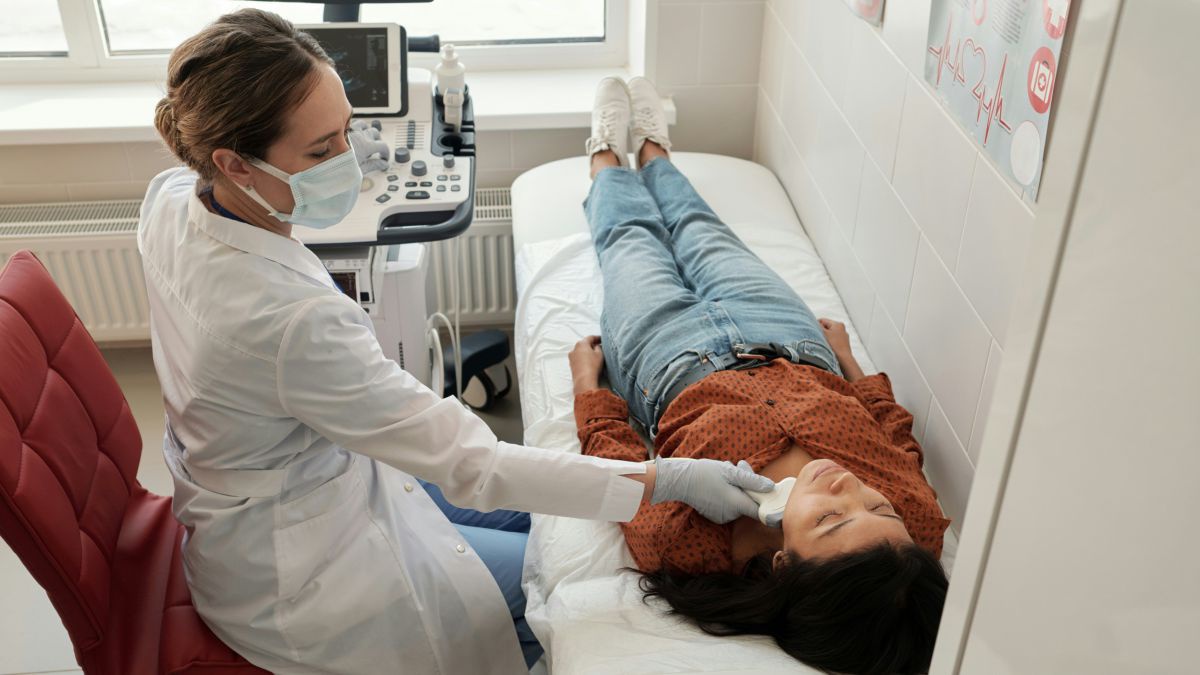 Eine Frau liegt auf einer Untersuchungsliege und wird von einer Ärztin untersucht.