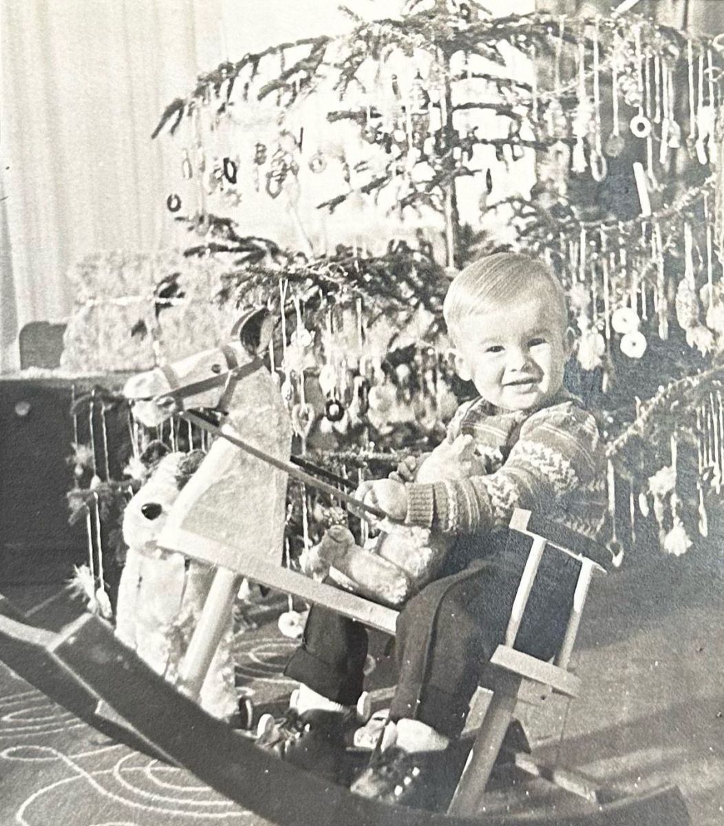 Schwarz-weiß-Foto von Opa Zusag zu Weihnachten 1958: Der kleine Junge sitzt auf einem Schaukelpferd vor dem geschmückten Christbaum.