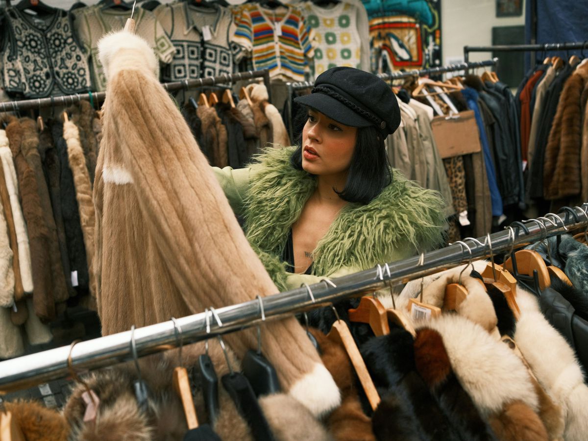 Eine junge Frau begutachtet eine Jacke in einem Second Hand Shop.